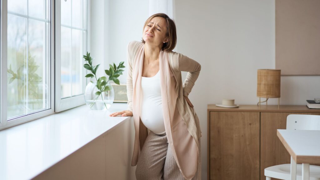 腰をおさえる妊婦さん